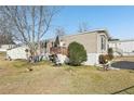Tan mobile home with a deck and well-maintained lawn at 127 Cambridge Ct, Hampton, GA 30228