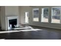 Bright living room with a fireplace, laminate floors, and several windows providing lots of natural light at 1105 Cooks Farm Way, Woodstock, GA 30189