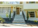 Steps leading to front door with wood door and black railing at 3613 Embry Cir, Chamblee, GA 30341