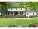Two-story white house with a large front yard and wrap around porch at 2100 Wood Ct, Marietta, GA 30062