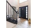 Elegant entryway with black staircase and light flooring at 4222 Honey Creek Way, Powder Springs, GA 30127