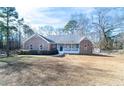 Attractive single-story home showcasing a brick exterior, covered entryway, and expansive front lawn at 4801 Daniel Mill Rd, Winston, GA 30187