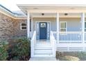 Inviting front porch with white railings and a charming blue front door with decorative wreath at 4801 Daniel Mill Rd, Winston, GA 30187