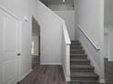 Hallway features wood-look flooring, neutral paint, and a staircase with carpeted steps at 250 Shawnee Trl, Dallas, GA 30157