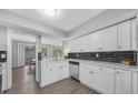 Bright kitchen features white cabinets, stainless steel dishwasher, and striking black subway tile backsplash at 2678 Greentree Se Dr, Marietta, GA 30067