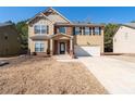 Two story house with brick and siding, two car garage, and landscaping at 313 Pennant Ln, Fairburn, GA 30213