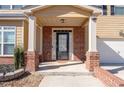 Brick front porch with columns and a black front door at 313 Pennant Ln, Fairburn, GA 30213