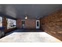 Carport with brick wall, showing entrances to the home and concrete flooring at 4453 White Oak Dr, Sugar Hill, GA 30518