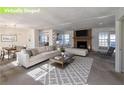 Bright, staged living room features a fireplace, white sofa, area rug and dining area at 4453 White Oak Dr, Sugar Hill, GA 30518