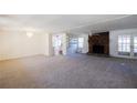 Spacious living room with a brick fireplace and doors to backyard providing ample natural light at 4453 White Oak Dr, Sugar Hill, GA 30518