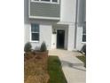 Townhome entrance with walkway, landscaping, and black front door at 310 Mcdonough Blvd # 103, Atlanta, GA 30315