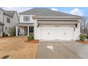 Rear exterior showcasing a spacious two-car garage and a well-manicured backyard at 6320 Halcyon Garden Dr, Alpharetta, GA 30005