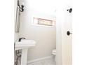 Small powder room featuring a corner sink and stained glass window, with a shower in the corner at 1830 W Taylor Ave, Atlanta, GA 30344