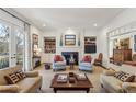 Elegant living room with fireplace, built-in shelving, and French doors leading to the outdoors at 11461 Hackett Rd, Roswell, GA 30075