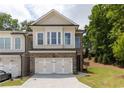 Charming two-story townhome with brick facade, two-car garage and well-manicured lawn at 1442 Casteel Lake Ln # 277, Buford, GA 30518