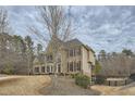 A large brick home on a hillside lot with a fenced backyard at 6620 Flagstone Mill Cv, Cumming, GA 30028