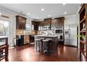 Spacious kitchen featuring stainless steel appliances, dark wood cabinets, and a granite-topped island with seating at 1567 Brunswick St, Lithia Springs, GA 30122
