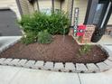 Landscaped yard with decorative stone edging, mulched flower beds, and 'Welcome' sign at 1370 Long Acre Dr, Loganville, GA 30052