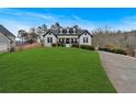 House exterior showcasing a spacious lawn and a long driveway leading to the home at 65 Centerport Dr, White, GA 30184