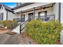 Charming front porch with black railings, columns, and lush landscaping at 65 Centerport Dr, White, GA 30184