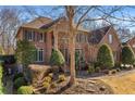 Two-story brick home with landscaping and a large tree in front at 920 Riverhaven Dr, Suwanee, GA 30024