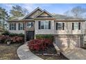 Two-story house with stone accents, a two-car garage, and manicured landscaping at 5424 Central Church Rd, Douglasville, GA 30135