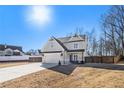 Two-story house with gray siding, a large driveway, and a fenced backyard at 61 Harmony Woods Ln, Dallas, GA 30157