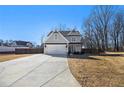 Two-story house with gray siding, a large driveway, and a fenced backyard at 61 Harmony Woods Ln, Dallas, GA 30157