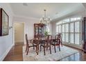 Formal dining room with hardwood floors, a chandelier, a large window, and stylish furnishings at 305 Glengarry Chase, Covington, GA 30014