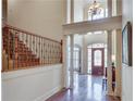 Grand foyer with hardwood floors, high ceilings, elegant staircase, and a decorative front door at 305 Glengarry Chase, Covington, GA 30014