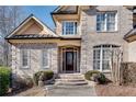 Close-up of a home's entrance with brick steps, decorative door, and manicured landscaping at 305 Glengarry Chase, Covington, GA 30014