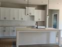 Modern kitchen features white cabinets, a center island, sleek black hardware, and subway tile backsplash at 8970 Callaway Dr, Winston, GA 30187