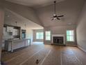 Open-concept living room with vaulted ceiling, fireplace, and an adjacent kitchen island for seamless entertaining at 8970 Callaway Dr, Winston, GA 30187