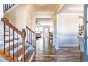 Inviting entryway with hardwood floors, elegant staircase, and a view into the living spaces at 115 Greenbrier Way, Canton, GA 30114
