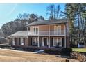 Two-story brick house with a balcony and rocking chairs on the porch at 1357 Ridgewood Dr, Lilburn, GA 30047