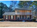Charming two-story home with a brick facade, balcony, black shutters, and a well-manicured lawn at 1357 Ridgewood Dr, Lilburn, GA 30047