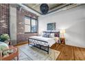 Cozy bedroom featuring hardwood floors, exposed brick, and a comfortable bed with stylish decor at 3180 Mathieson Ne Dr # 703, Atlanta, GA 30305