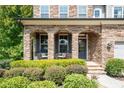 Stone front porch with rocking chairs and landscaping at 520 Andes Ln, Canton, GA 30114