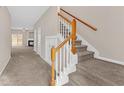 Carpeted staircase with wood railing and storage at 432 Lantern Wood Dr, Scottdale, GA 30079