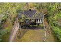 Aerial view of a cozy house with a well-manicured lawn and driveway nestled among lush trees at 2597 Elsinore St, East Point, GA 30344