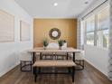 Dining area with hardwood floors, a wood table, and an accent wall at 8228 Walnut Hall Dr, Fairburn, GA 30213