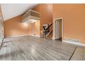 Open living room with vaulted ceilings, gray laminate floors, upstairs balcony and access to staircase at 3284 Huntwood Dr, Decatur, GA 30034