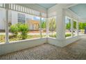 Large wraparound porch with brick flooring and white columns at 11577 Serenbe Ln, Chattahoochee Hills, GA 30268
