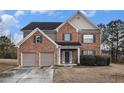 Charming two-story home with a brick facade, a two car garage, and well-maintained landscaping at 436 Margaux Way, Atlanta, GA 30349