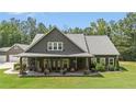 Attractive home with covered porch, stone accents, and a well-maintained lawn with mature trees at 764 Little Vine Church Rd, Villa Rica, GA 30180