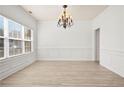 Bright dining area with decorative trim, chandelier, and window with natural light at 6170 Pierless Lndg, Sugar Hill, GA 30518