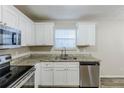 Well-lit kitchen with stainless steel appliances, granite countertops, and ample cabinet space at 5925 S Quail Dr, Douglasville, GA 30135