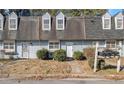 View of two light blue townhouses with grey roofs and landscaping at 6406 Abercorn St, Union City, GA 30291