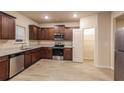 Well-lit kitchen featuring wood cabinets, stainless steel appliances, and a pantry at 148 Oliver Dr, Locust Grove, GA 30248