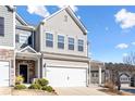 Two-story townhome with gray siding, white garage door, and landscaping at 38 Rocky Knl, Dallas, GA 30157